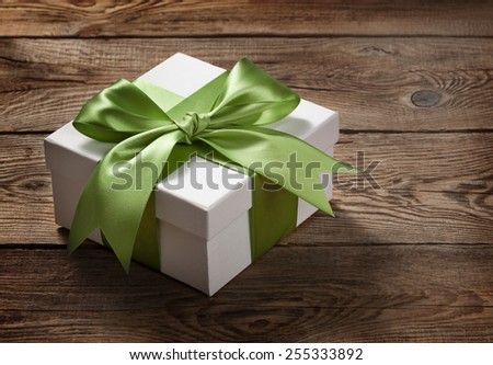 Beautiful gift box with a bow on the table from the old boards