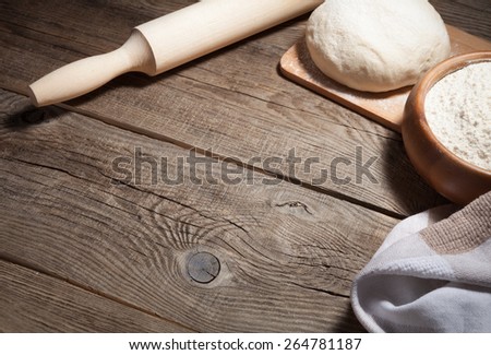 dough, flour and rolling pin on an old board.