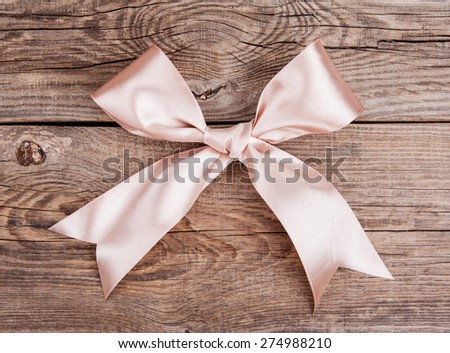 Pink bow lying on the old board