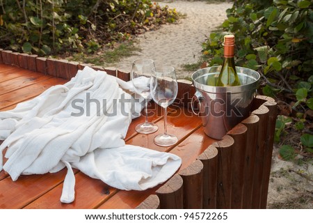 Champagne bottle in ice bucket with  glasses on the deck of a beach resort