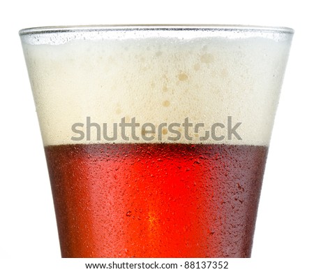 Close up of cold beer in a frosted pilsner style glass with head at rim level, showing half beer and half head