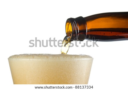 Close up of cold beer pouring into a frosted pilsner style glass showing only head