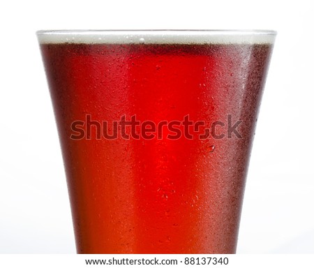 Close up of a full to rim cold beer in pilsner style glass with no head