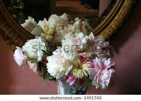 vase with flowers at antique mirror