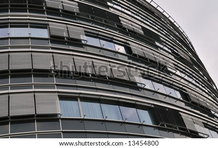 Oval modern office building detail showing windows and blinds.
