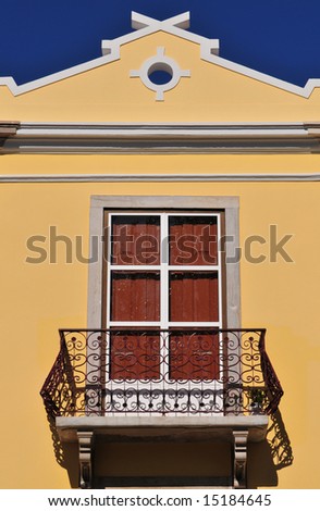 Closed window with balcony at the top level of the house.