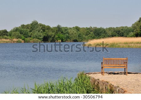 Empty wooden bench at Lake Tisza (largest artificial lake in Hungary).