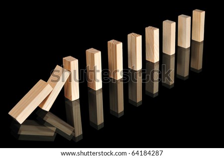 Wooden blocks with reflections representing a chain reaction isolated on black.