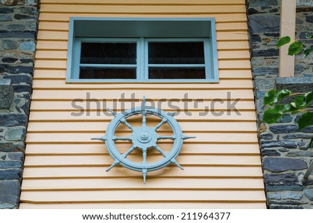 steering wheel of a ship on a facade of a house