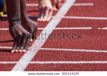 hand of runners on starting line in stadium