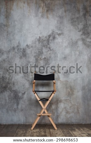 Empty directors chair against grungy wall