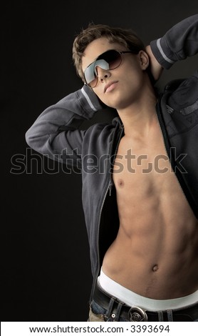 Young fashion man model with athletic body posing in sun glasses Young fashion man model with athletic body posing in sun glasses