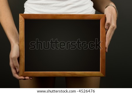 Wooden frame in woman hands ready for your text or logo