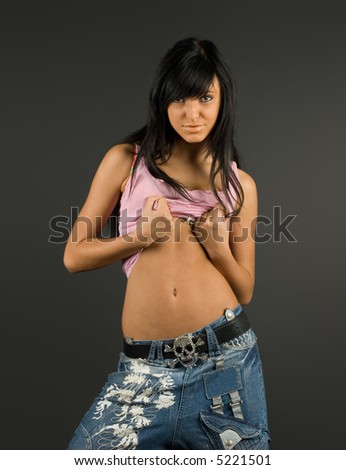 Young and fashionable brunette  posing in pink t-shirt and blue jeans