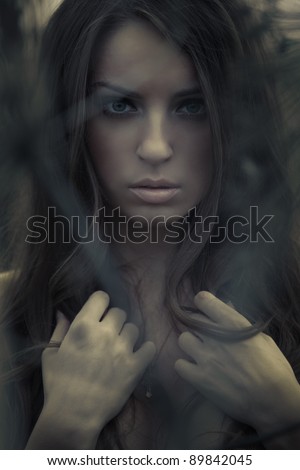 Beautiful young topless woman posing outdoors. Dark mysterious artistic portrait.