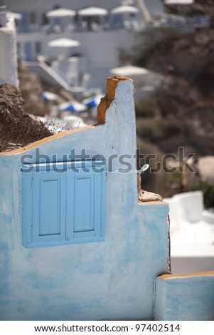 The part of a wall with beautiful view at the villas on the background. Oia, Santorini, Greece.