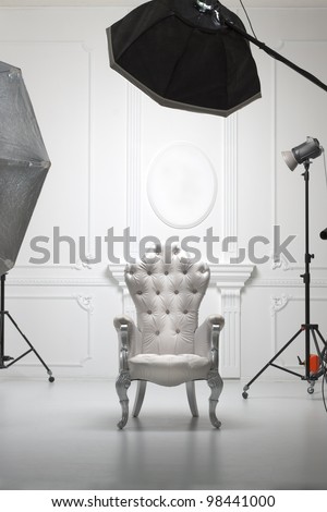 White antique chair in photographic studio with modern lighting equipment