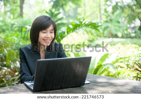 Woman sitting use computer on wooden table at home office