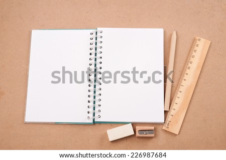 open diary or photo album book on brown backgroun has pencils, erasers, rulers