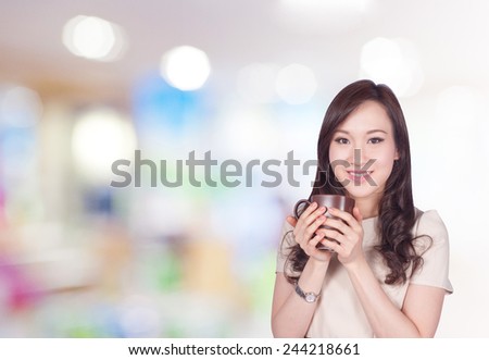 Portrait of young asia business woman 20-30 year old hold cup of coffee in shopping mall.Mixed Asian / Caucasian businesswoman.