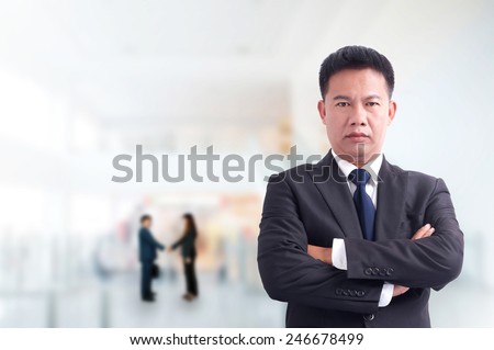 Portrait of young asia businessman has office background .cross one\'s arm,Positive emotion