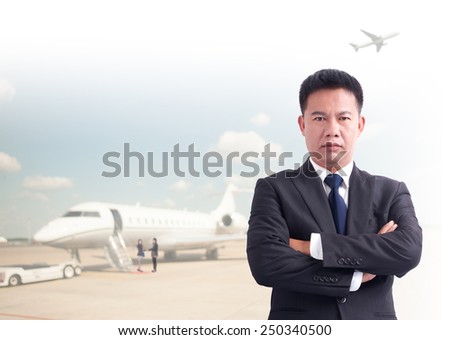 Portrait of young asia businessman has airport background .cross one\'s arm,Positive emotion