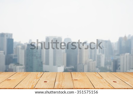 blurred city in sunny day backgrounds with old vintage wooden desk tabletop: put and show your products on display or wallpaper