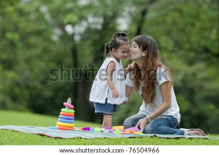 Mother kiss daughter is a small garden.