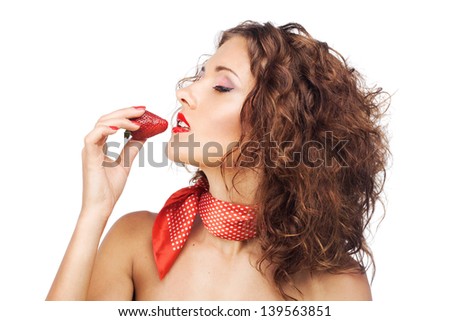 Beautiful seductive woman eating a strawberry