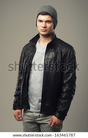 Studio picture of young handsome man in black leather jacket
