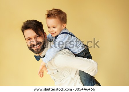 Happy little boy enjoying with riding on father\'??s back
