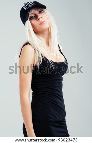 Beautiful blonde in a black clothing against gray background