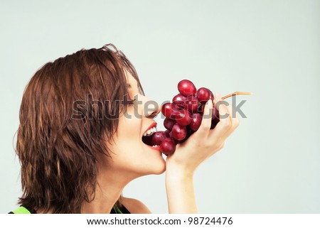 Lovely woman eating grapes