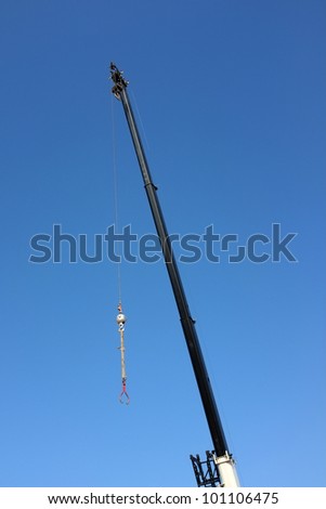 Long mast of hydraulic crane with cable, ball and tongs ready for load