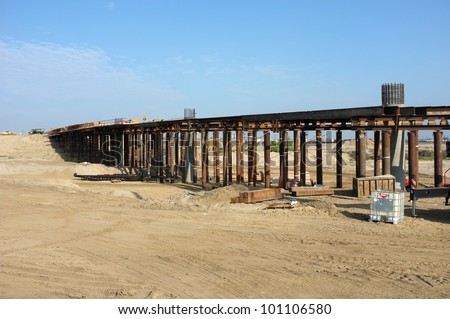 Bridge Construction Project: Reinforced concrete columns and temporary wood and steel shoring support roadway before concrete is poured
