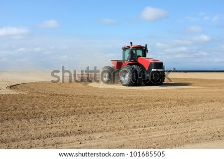A Central California farmer pulls a disker behind his tractor to prepare for spring planting