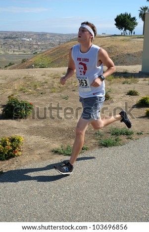 BAKERSFIELD, CA - MAY 26:  An unidentified male contestant finds the pace fast and the weather hot during the Running Xrew Invite 5k race on May 26, 2012, at Bakersfield, California.