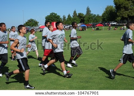 BAKERSFIELD, CA - JUNE 9: Boys sprint to get in shape for the Golden Empire Youth Football Camp at Bakersfield Community College on June 9, 2012,  in Bakersfield, California.