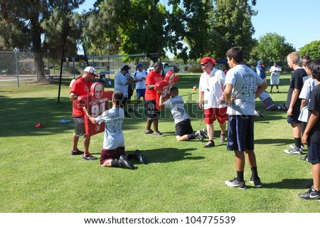 BAKERSFIELD, CA - JUNE 9: Coaches teach the fundamentals of the game to boys at the Golden Empire Youth Football Camp at Bakersfield Community College on June 9, 2012,  in Bakersfield, California.