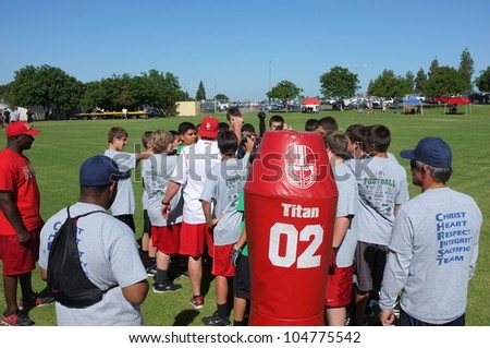 BAKERSFIELD, CA - JUNE 9: Coaches teach the fundamentals of the game to boys at the Golden Empire Youth Football Camp at Bakersfield Community College on June 9, 2012,  in Bakersfield, California.