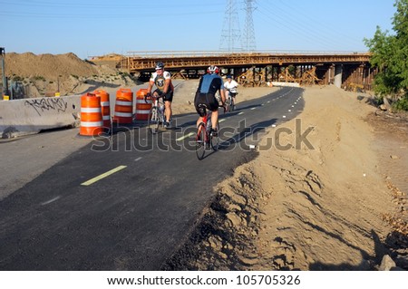 BAKERSFIELD, CA-JUN 21: Showing contrasting transportation modes, unidentified cyclists must temporarily use the detour under the Westside Parkway project on June 21, 2012, in Bakersfield, California.