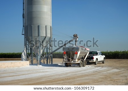 Agricultural chemicals are loaded from a storage tank into a trailer-mounted hopper on a Central California farm