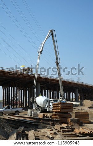 BAKERSFIELD, CA-OCT 16: Concrete pouring has begun on new bridge across the Kern River by pumping in flexible hoses supported by articulated cranes on October 16, 2012, in Bakersfield, California.
