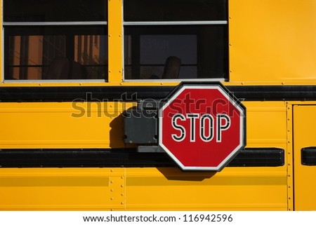 Many children rely on the iconic yellow school bus for transportation; detail of stop sign.