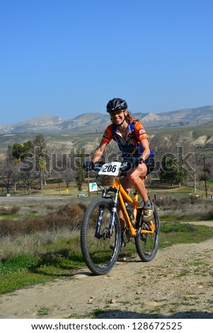 BAKERSFIELD, CA-FEB 17: An unidentified female rider powers up a steep hill during the Foothill Classic Cross Country Mountain Bike Race on February 17, 2013, in Bakersfield, California.