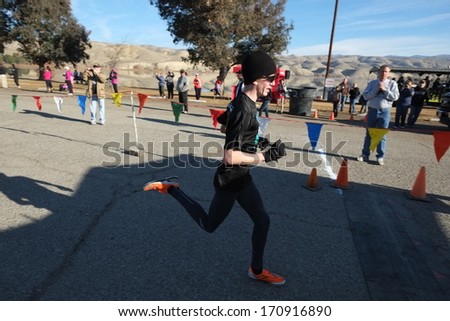 BAKERSFIELD, CA - JAN 11, 2014: An unidentified male runner finishes with a kick at the 24th Annual Fog Run. The weather is perfect, not at all foggy.
