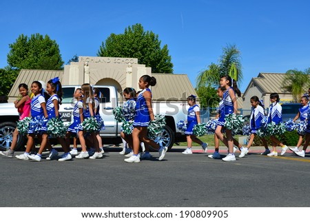 SHAFTER, CA - MAY 3, 2014: These little girls, members of the Redwood School\'s pep squad,  are on their way to march in the Cinco de Mayo Celebration parade.