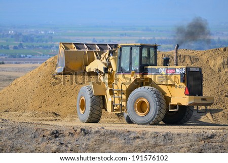 BAKERSFIELD, CA-MAY 7, 2014: A front end wheel loader quickly moves dirt along the new roadway portion as work is now about 30% complete on the widening of State Route 178.