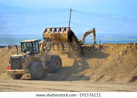 BAKERSFIELD, CA-MAY 7, 2014: A front end wheel loader quickly moves dirt along the new roadway portion as work is now about 30% complete on the widening of State Route 178.