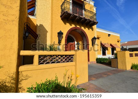 A California building shows a strong Mexican or Spanish architectural influence with warm, bold colors.